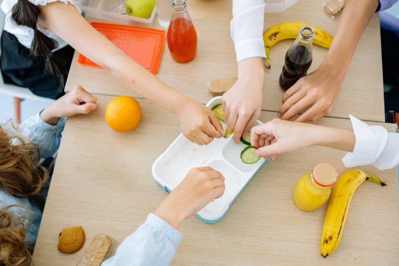 Children enjoying a variety of healthy snacks and drinks at a shared table, top view.