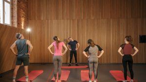 Men and women performing stretching exercises on mats in a fitness class